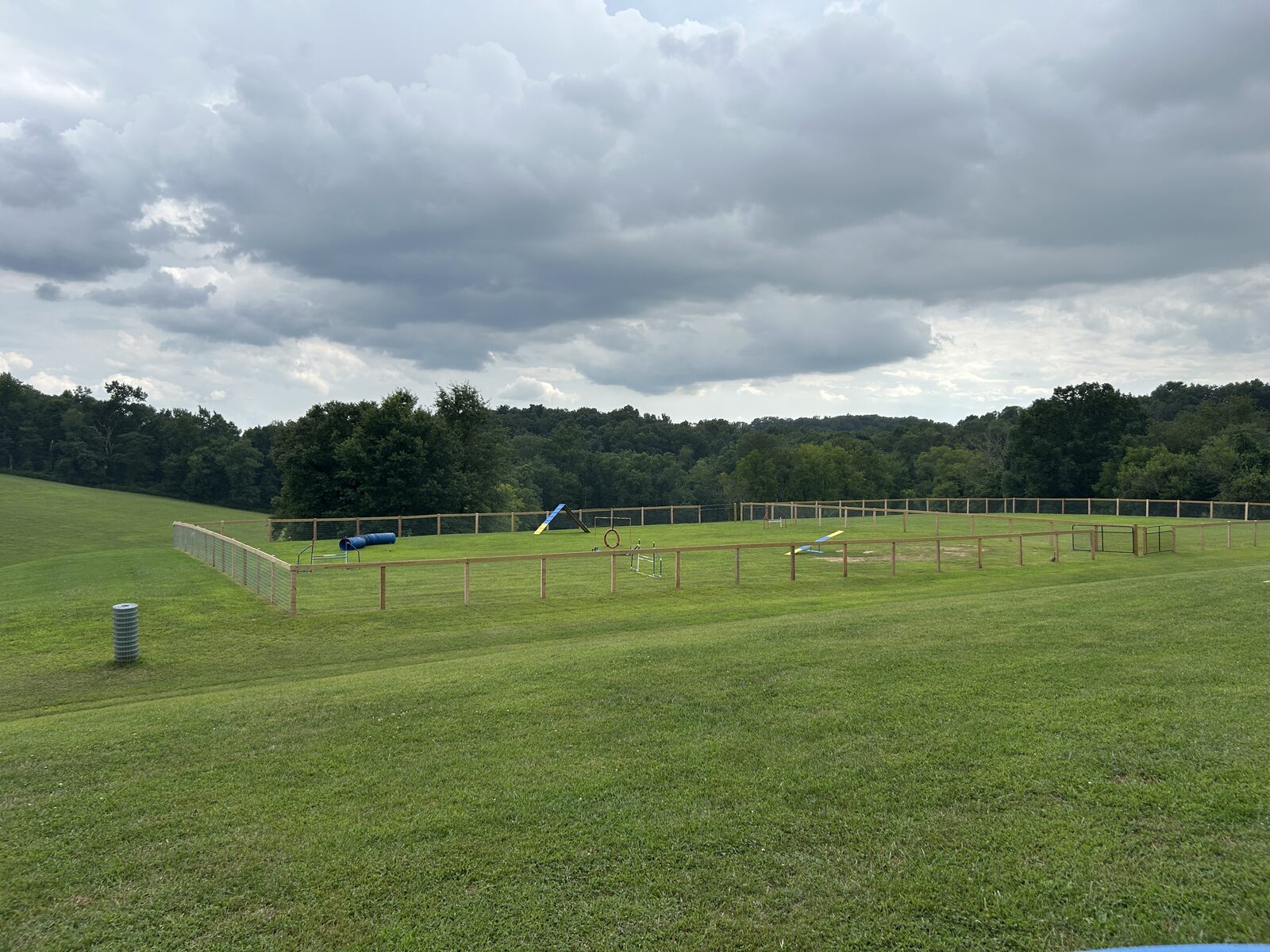 Dog agility course with tunnel, A-frame, and weave poles in Training Area 1